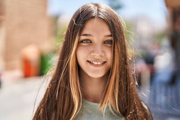 Schattig meisje glimlachend zelfverzekerd kijkend naar de camera op straat - Foto, afbeelding