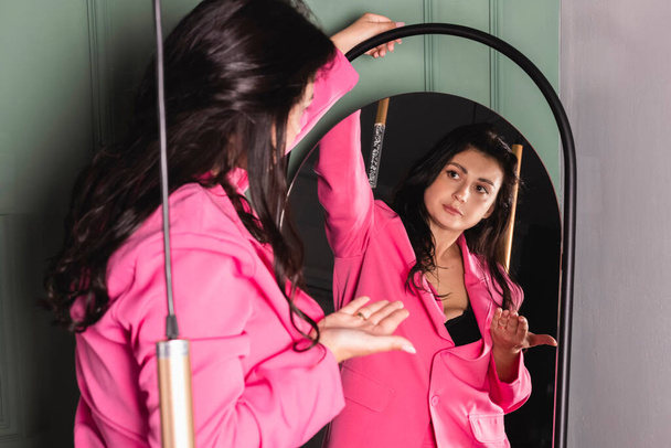 The girl is rehearsing a speech, talking to herself in the mirror. - Фото, зображення