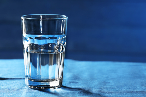 Glass of water on table on wooden background - Foto, Imagem