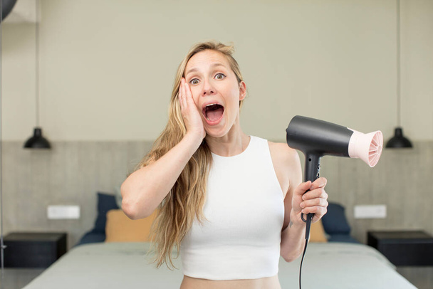 feeling happy and astonished at something unbelievable. hair dryer concept - Zdjęcie, obraz
