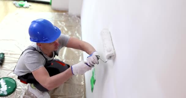 Costruttore casa pittore e tuta dipinge parete con rullo in bianco. Servizi di verniciatura di pareti e soffitti di qualità - Filmati, video