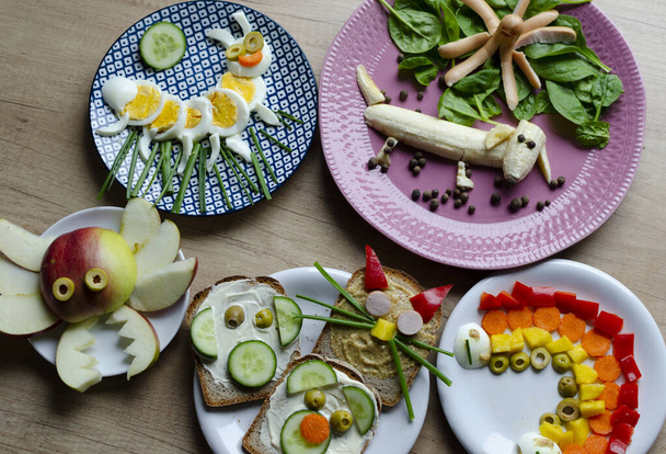 Healthy meal with vegetables and fruit for children on breakfast. Fun food and creative dish in the morning. Colorful eating on a table. - Photo, image