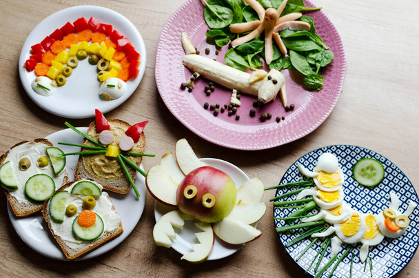 Colorful food for kids in different shape on a plate on a table. Fun food and meal for breakfast with decoration. Creative morning in the kitchen. - Fotoğraf, Görsel