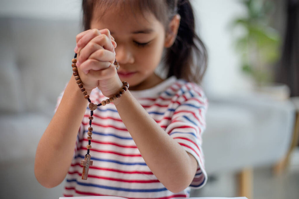 Християнська концепція. Маленька азіатка молиться, щоб не впустити хреста. Концепції надії, віри, християнства, релігії,  - Фото, зображення