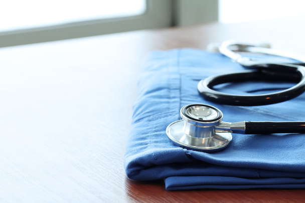 Stetoskop z lekarza niebieski płaszcz na drewnianym stole z płytkich D - Zdjęcie, obraz