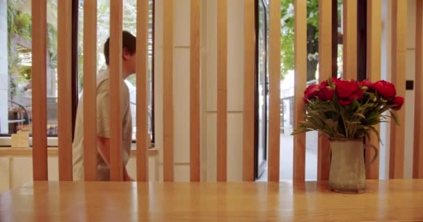  木製のスラットの壁。木製の椅子とテーブル付きのモダンなミニマリストカフェ。モダンな木製の椅子とテーブル。環境に優しいカフェ。空のダイニングファブリックと木製の椅子。顧客を受信するための木製のカウンター. - 映像、動画