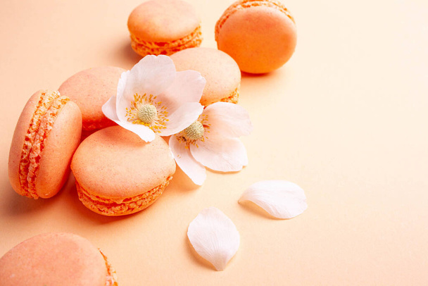 Помаранчеві макарони на персиковому фоні. Смачний десерт
 - Фото, зображення