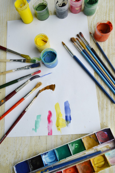 Set of brushes and paints on wooden table - 写真・画像