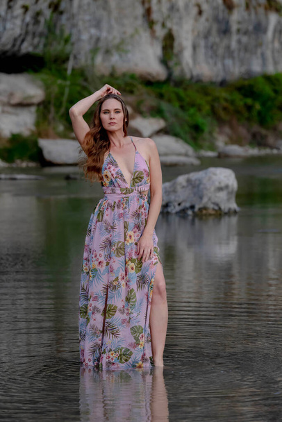 A gorgeous brunette model enjoys the summer weather near a lake - Fotó, kép