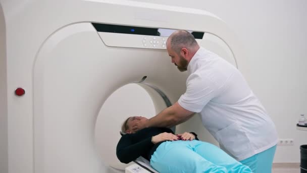 Radiologi suorittaa tietokonetomografiatoimenpiteen klinikalla Potilaalle tehdään pään tutkimus - Materiaali, video