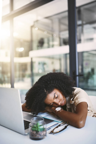 Todos cansados de tanto trabajo. una joven empresaria feliz durmiendo en su escritorio en una oficina moderna - Foto, Imagen