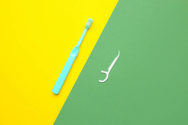 Floss tandenstoker en borstel op kleurrijke achtergrond - Foto, afbeelding