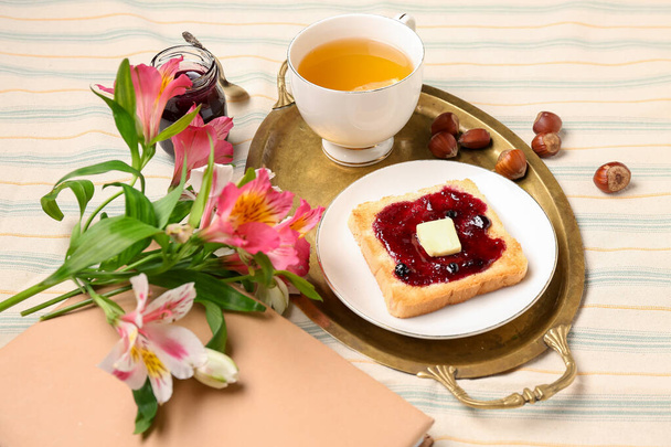 Chutný toast s džemem, šálkem čaje a krásnými květy na stole - Fotografie, Obrázek