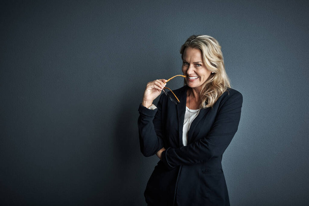 Ive always had a mind for business. Studio portrait of a mature businesswoman posing against a grey background - Fotó, kép
