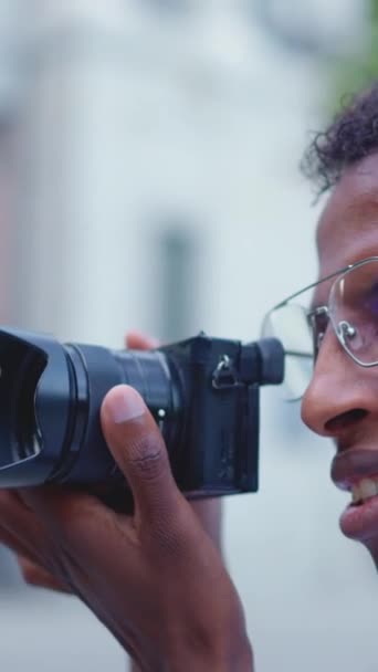 Close up profile of a african photographer taking a photo in the street - Filmmaterial, Video
