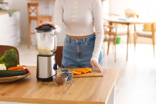 Молода жінка робить здорову смужку з блендером на кухні
 - Фото, зображення