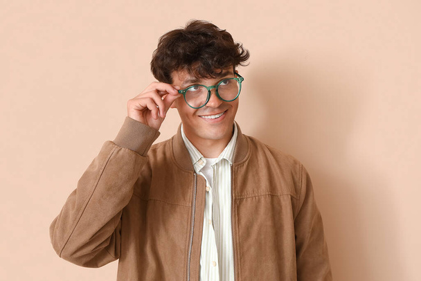 Giovane in occhiali alla moda su sfondo beige - Foto, immagini