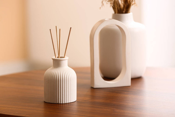 Bottle of reed diffuser and decor on table in room, closeup - Valokuva, kuva