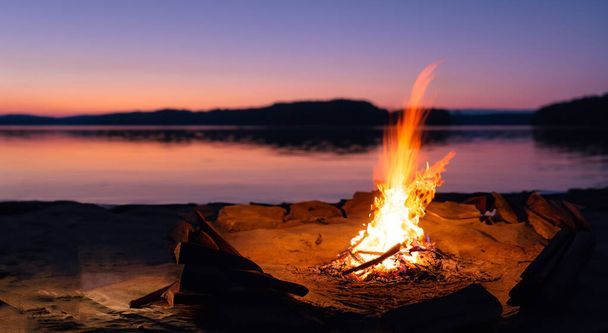 beau feu de camp au milieu de la plage au beau coucher de soleil terne - Photo, image