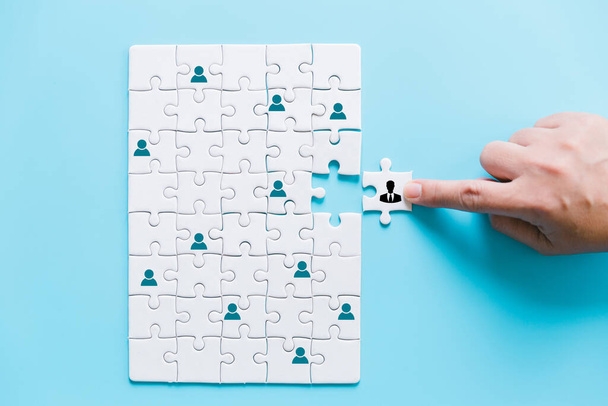 Zarządzanie zasobami ludzkimi i rekrutacja firmy budować koncepcję zespołu. Obraz tangram puzzle bloki z ikonami ludzi nad drewnianym stole, zasobów ludzkich i koncepcji zarządzania. - Zdjęcie, obraz