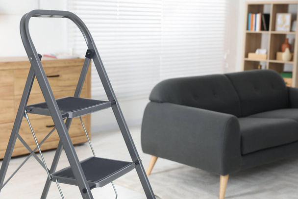 Metal folding ladder in stylish living room - Foto, afbeelding