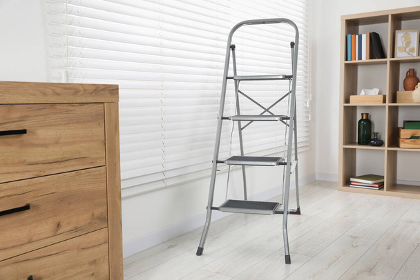 Metal folding ladder in stylish living room - Фото, зображення