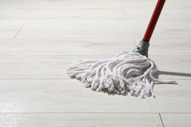 Cleaning white parquet floor with mop, closeup. Space for text - Фото, изображение