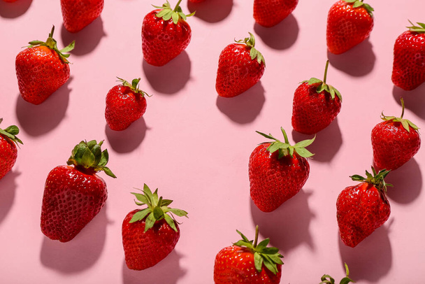 Beaucoup de fraises fraîches sur fond rose - Photo, image