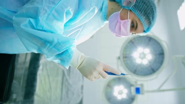 verpleegkundige of chirurg in steriele handschoen met scalp chirurgisch instrument in de hand tijdens de operatie close-up - Video