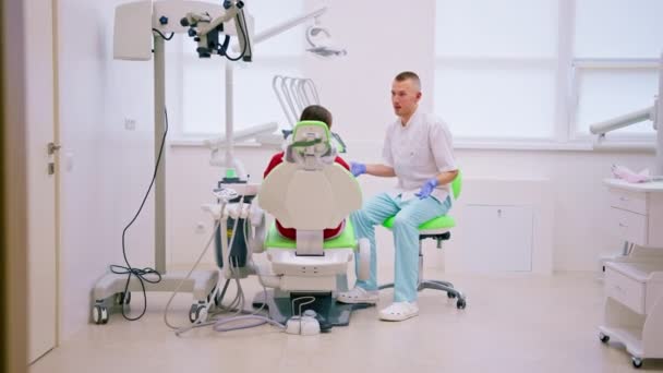 pacjent na wizycie u dentysty skarży się na ból zęba i próchnicy lekarz doradza jej przed badaniem - Materiał filmowy, wideo