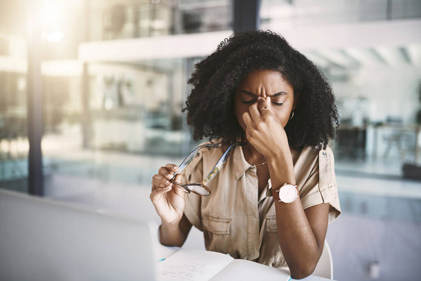 O stress está a custar-lhe a produtividade. uma jovem empresária olhando estressado em sua mesa em um escritório moderno - Foto, Imagem