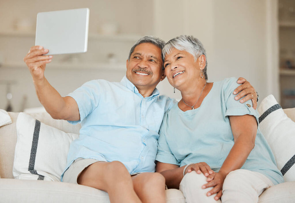 Teknologia, selfie ja aviopari tabletti sohvalla olohuoneessa kotinsa. Onnellisuus, sosiaalinen verkostoituminen ja rakkaus vanhusten kanssa online-videopuhelussa, jossa on internetyhteys. - Valokuva, kuva