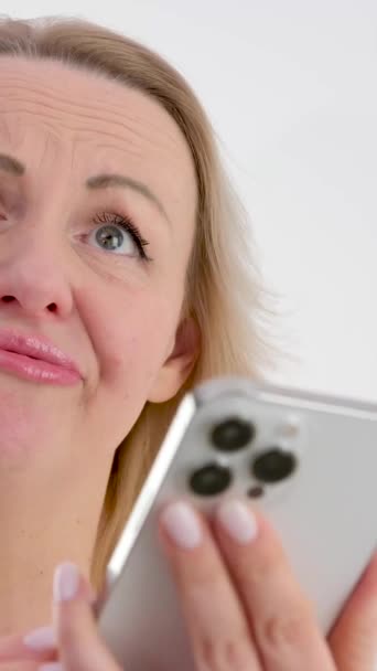 Нервная женщина смотрит на экран мобильного телефона, чувствуя себя расстроенной из-за получения сообщения или электронной почты с плохими новостями. Несчастная женщина-пользователь тысячелетия недовольна плохой работой электронного устройства - Кадры, видео