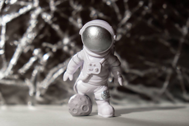 Plastic toy figure astronaut on silver background Copy space. Concept of out of earth travel, private spaceman commercial flights. Space missions and Sustainability - Photo, image