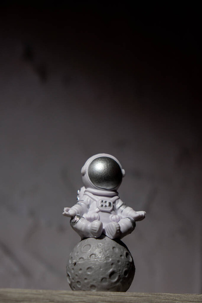 Plastik oyuncak figürü astronot Ay 'ın arka planında beton kopyalama uzayı. Dünya dışı seyahat kavramı, özel uzay adamı ticari uçuşları. Uzay görevleri ve Sürdürülebilirlik - Fotoğraf, Görsel