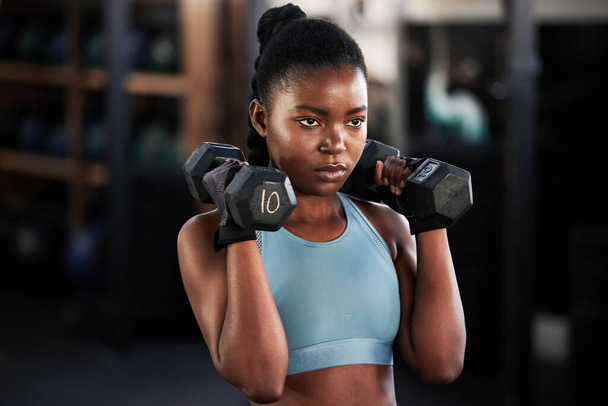 Фізичність, нісенітниці або сильна підготовка темношкірих жінок, вправи або тренування для сильних рук або м'язів. Зло, здоров'я або африканська дівчинка піднімає вагу або робить фізичні вправи з енергією в спортзалі студії. - Фото, зображення