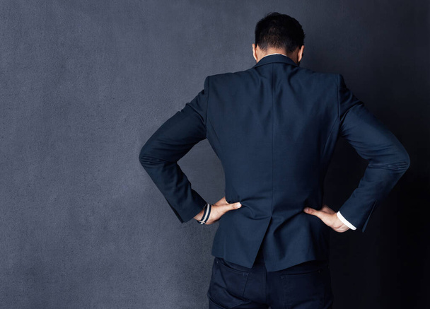 Turning his back on business. Rearview studio shot of a businessman standing against a gray background - Foto, Imagem