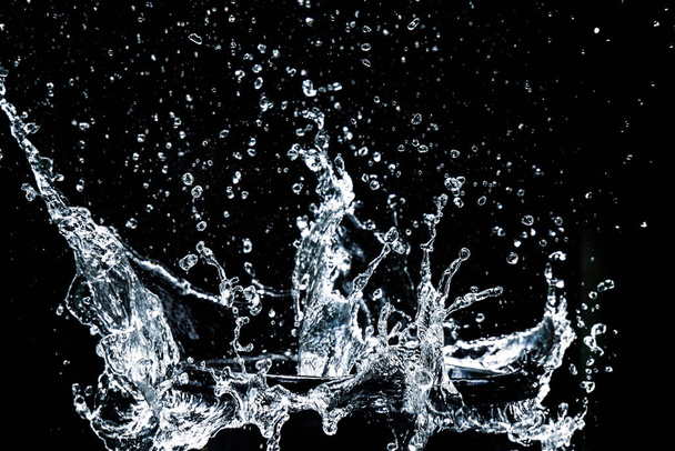 Roiskeita vettä mustalla pohjalla. vesipisara virkistävä musta tausta - Valokuva, kuva