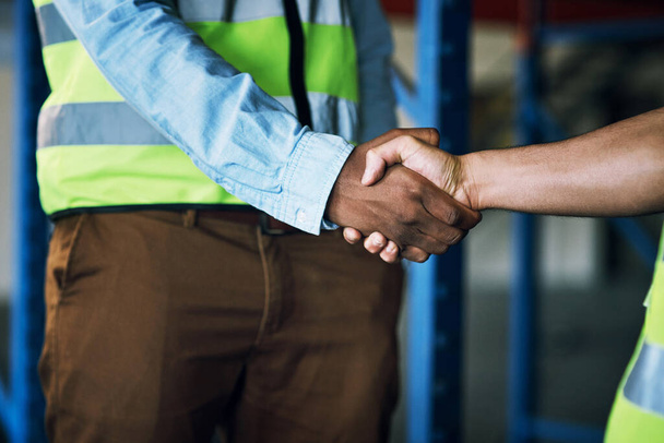 People, architect and handshake in construction, building or hiring in teamwork partnership on site. Contractor men shaking hands in recruiting, architecture agreement or industrial deal at warehouse. - Foto, Imagen