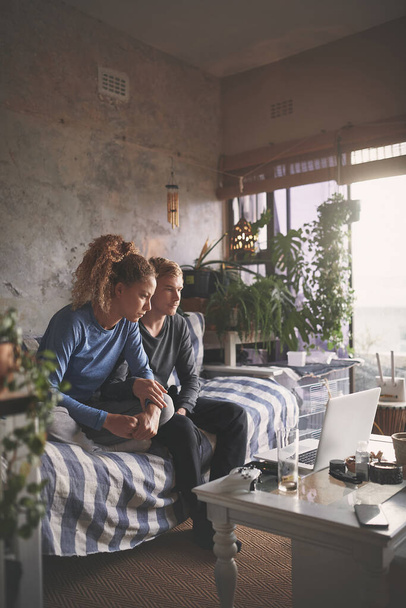 Будинок є найбільш охолодженим місцем відпочинку. молода пара використовує ноутбук на дивані вдома
 - Фото, зображення