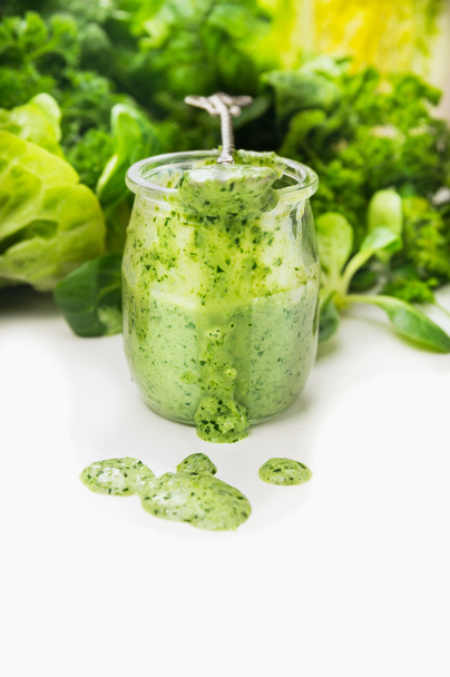 Green vegetables smoothie in glass jar and spoon on white background - Fotoğraf, Görsel