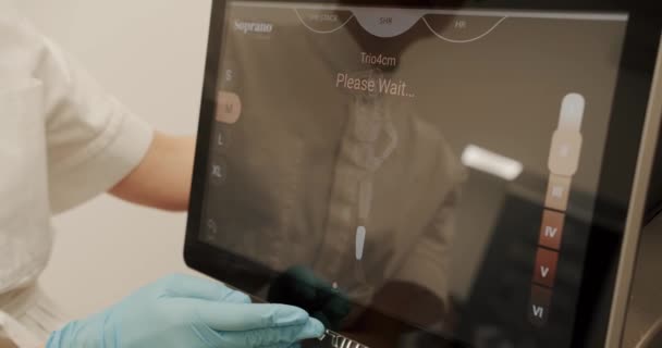 Close-up van arts handen schakelt laser apparatuur voor de procedure, Beautician configureren op een display laser ontharing apparaat. arts kiezen schoonheid procedure aanraken apparatuur weer te geven. - Video