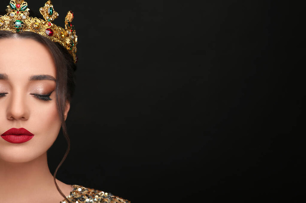 Beautiful young woman wearing luxurious crown on black background, closeup. Space for text - Zdjęcie, obraz
