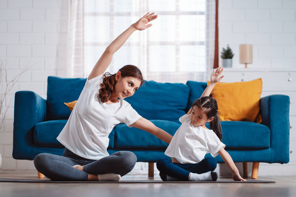 Mother and daughter exercising together happily at home. for flexibility build muscle strength, Sport workout training family together concept. - 写真・画像