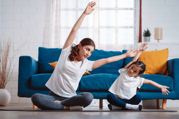 Mother and daughter exercising together happily at home. for flexibility build muscle strength, Sport workout training family together concept. - Foto, immagini