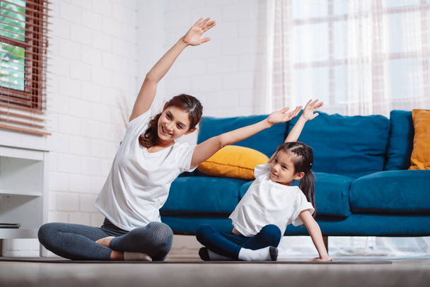 Mother and daughter exercising together happily at home. for flexibility build muscle strength, Sport workout training family together concept. - Фото, зображення