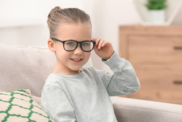 Portrait of smiling little girl wearing glasses indoors - Foto, Imagem