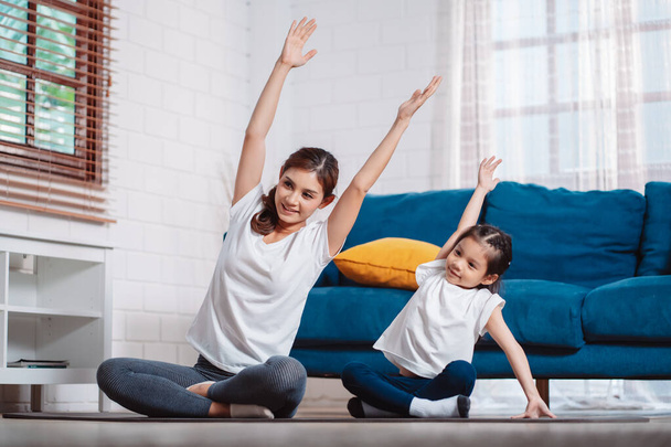 Mother and daughter exercising together happily at home. for flexibility build muscle strength, Sport workout training family together concept. - Foto, Bild