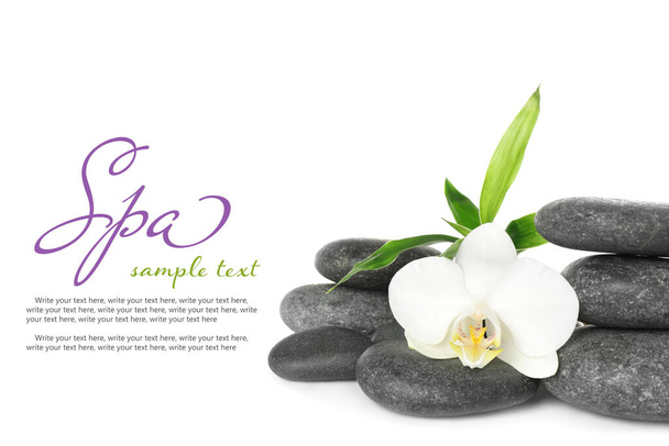 Spa stones , orchid and bamboo leaves on white background. Design with space for text - Photo, image