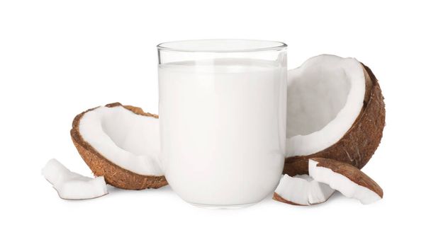 Lasi herkullista vegaanista maitoa ja kookospaloja valkoisella taustalla - Valokuva, kuva